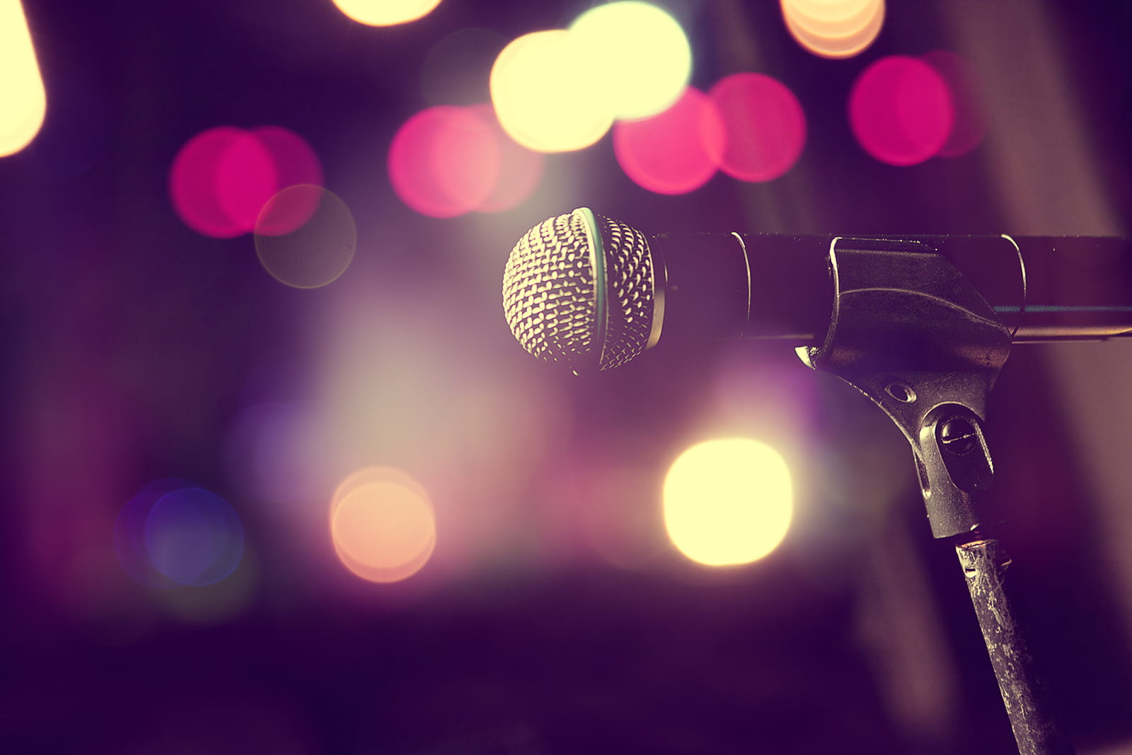 Microphone in front of hazy bokeh stage lights